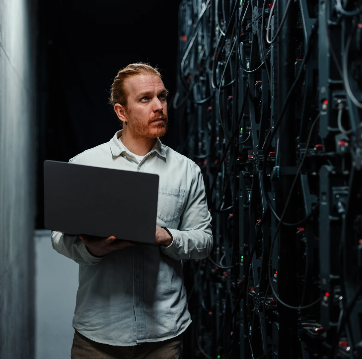 Man with laptop in server room